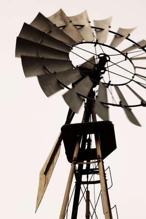 Old classic american windmill close-up. Propeller in motion. Vertical composition. Sepia - style photograph.の写真素材