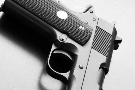 Weapon legends  Black and white picture of 1911 series army pistol on a wooden surface close-up  Studio shot の写真素材