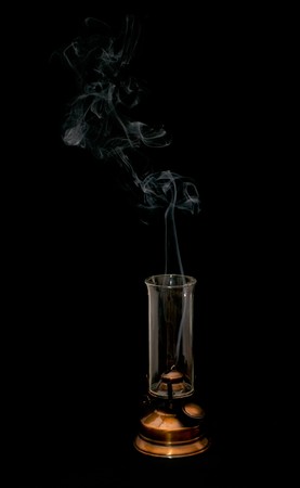 extinct oil lamp and smoke isolated on blackの写真素材
