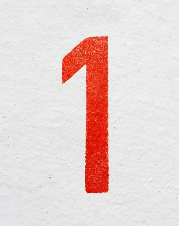 Red stenciled number One on old painted wall の写真素材