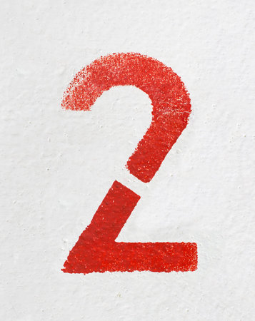 Red stenciled number Two on old painted wall