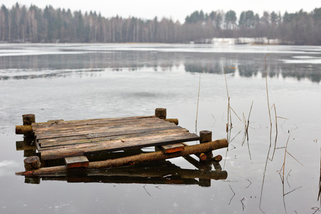 old wooden bridge on a frozen lake in winterの写真素材