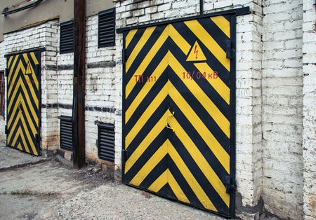 two old wooden doors with yellow and black stripeの写真素材