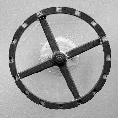 old hand wheel on the wall of big oil tankの写真素材
