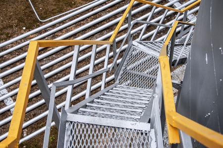 old staircase to the fuel tank, painted silver paint with yellow railingsの写真素材