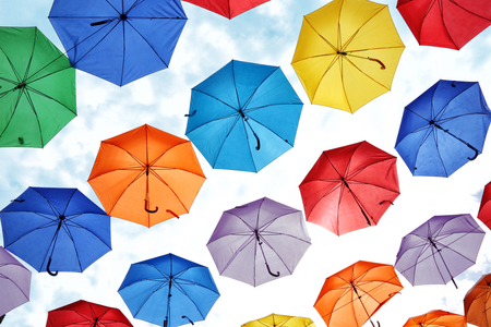 colorful umbrellas hanging against the sky. decorating the city streetsの写真素材