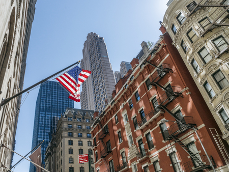 New York, USA - September 20, 2015: American flag flatters on the background of old buildings in New York.のeditorial素材