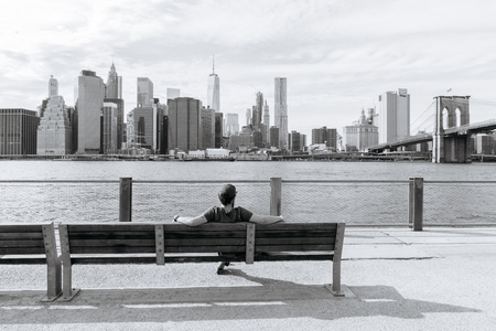 New York, USA - September 21, 2015:  The man sits on the bench and admire of the downtown of New York.のeditorial素材