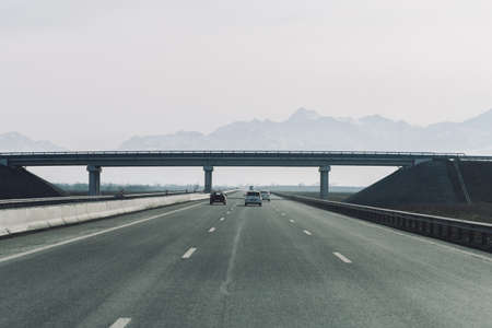 Gudauri, Georgia - February 12, 2016: Cars move along the highway towards the mountains.のeditorial素材