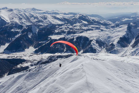 Gudauri, Georgia - February 16, 2016: Paragliding with beautiful cloudscape backgroundのeditorial素材
