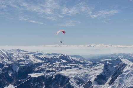 Gudauri, Georgia - February 16, 2016: Paragliding with beautiful cloudscape backgroundのeditorial素材