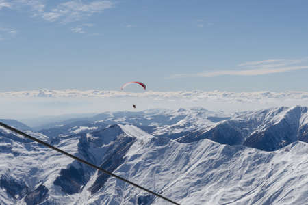 Gudauri, Georgia - February 16, 2016: Paragliding with beautiful cloudscape backgroundのeditorial素材