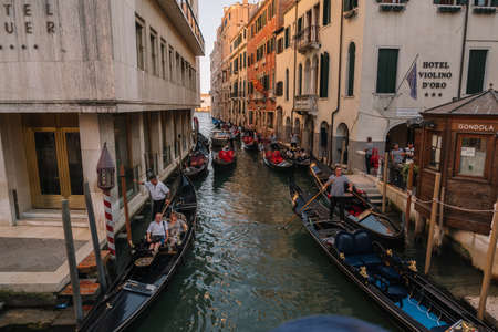 Venice, Italy - August 13, 2016: Gondoliers are driving a gondolas with tourists on the canal of Venice, Italy.のeditorial素材