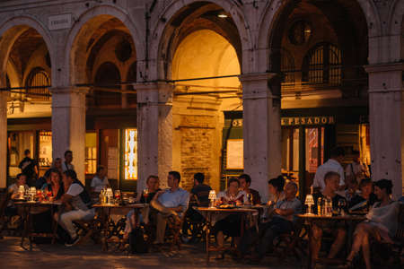 Venice, Italy - August 13, 2016: People are sitting at the restaurants of the Grand Canal promenade in the evening lights in Venice, Italy.のeditorial素材