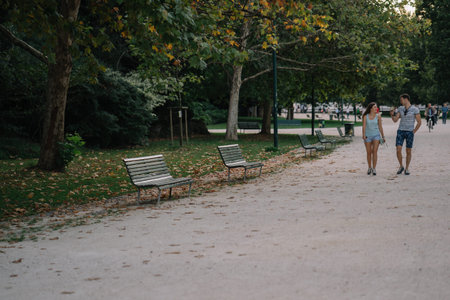 Milan, Italy - August 10, 2016: Woman and man talking walk in the park in the center of Milan,...