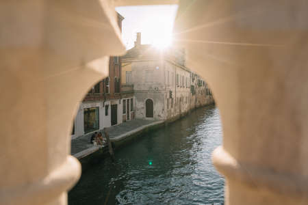 Venice, Italy - August 13, 2016: Deserted canal of Venice, Italy, only one couple of people sit on the shore and have dinner.のeditorial素材