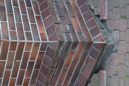 Architectural corner junction of red brick building displaying classic European construction techniques and weathered stone foundationの写真素材