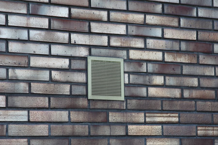 Brick wall with a ventilation grate installedの写真素材