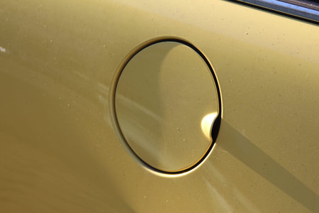 Minimalist golden yellow surface with single black circular ring creating geometric shadow patternの写真素材