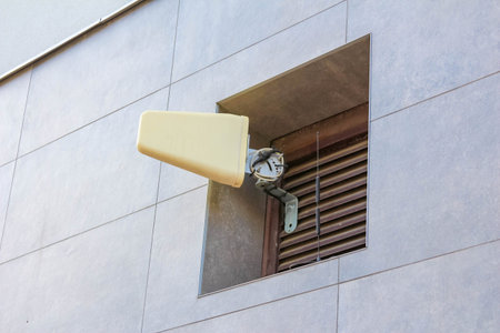 Architectural detail with horizontal slats creating shadow patterns on white building wall