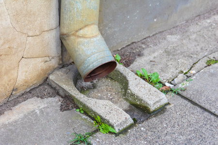 Stone drainage system with moss growth showing natural water management in urban environment