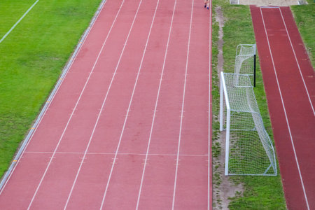 Multiple parallel running lanes on red athletic track surface with precise white boundary markings