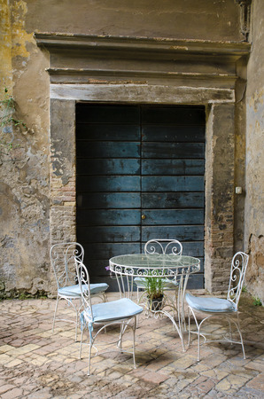 Vintage table and chair in the yard of an old houseの写真素材