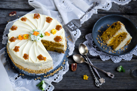 Carrot cake with cream cheese frosting on  wooden background