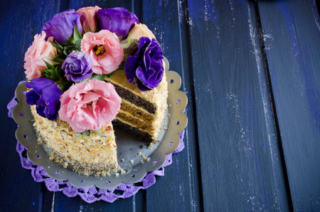 Cake with almonds and poppy seeds on a dark wood background