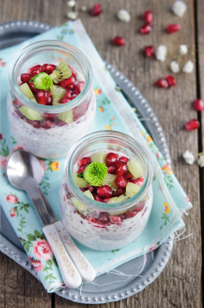 Pomegranate and kiwi chia seeds pudding in a jar for breakfastの写真素材
