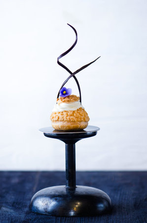 Fresh choux pastry on dark wooden background