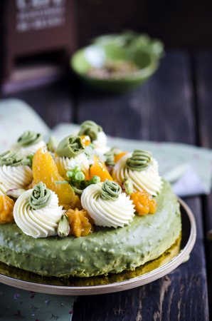 Pistachio cake with with apricot cream on wooden table.の写真素材