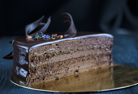 Chocolate cake with dark chocolate and raspberry under chocolate icinglazedの写真素材