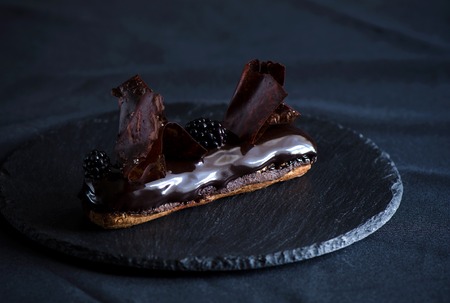 Chocolate choux pastry, chocolate crumble, creme caramel with black chocolate, chantilly with beans thin, extra-black glaze and crunchy chocolate flakesの写真素材