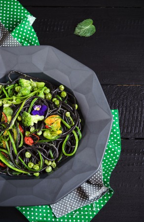 Pasta with cuttlefish ink and with fresh vegetablesの写真素材
