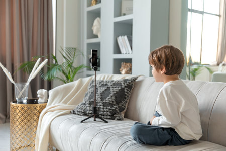 preschool caucasian blogger chats via video call on smartphoneの写真素材