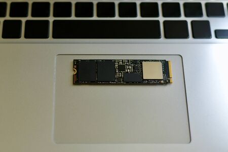 SSD drive on the trackpad. Against the background of the laptop keyboard. No signed blank buttons for text. In color.の写真素材