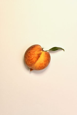 Ripe yellow red peach with green leaves. With a light shadow bottom. On a light background in the...