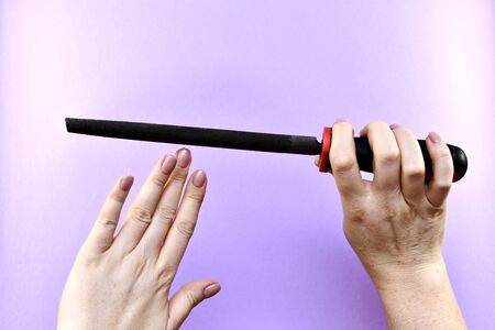 Female hands with a file, manicure, nail file cutting.の写真素材