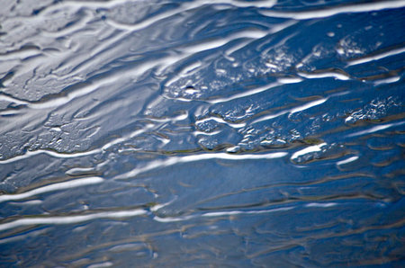 Long, oblique blurred in the line of raindrops on the glass.