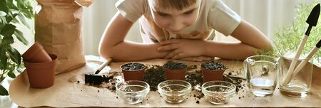 In the atmosphere of the working environment, the child bent down and observes the result of his work.の写真素材