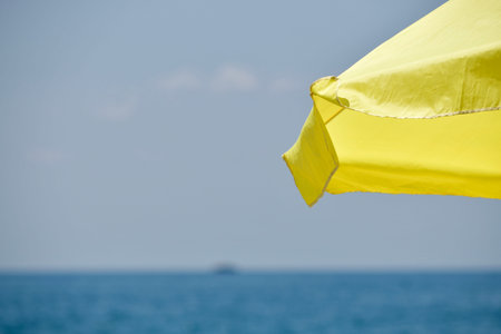 Yellow fragment of the visor of the umbrella without a leg beach umbrella awning. Open against the...