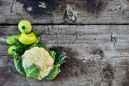 Green fresh whole vegetables on a wooden rough substrate.の写真素材