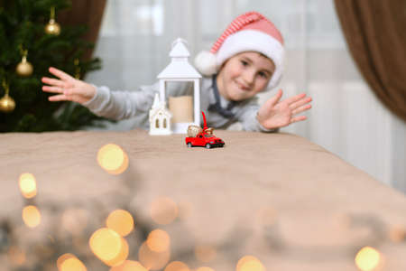 A child with open arms and a smile greets the car with New Year's gifts at home in a festive atmosphere.の写真素材