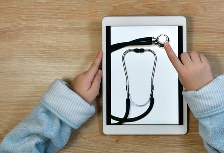A finger pointing to the membrane head of a stethoscope in the tablet screen. Calling an ambulance doctor.の写真素材