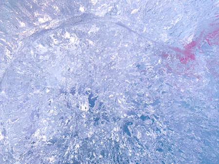 The abstract background of the ice cut is blue with a purple tinge and a crimson blurry spot.の写真素材