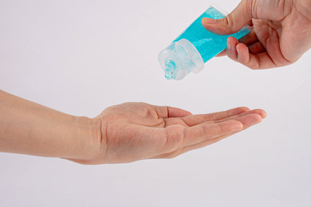 Male hand using hand skin sanitizer gel tube for washing hand on white background