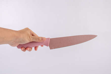 Hand is holding a kitchen kinfe isolated on a white backgroundの写真素材