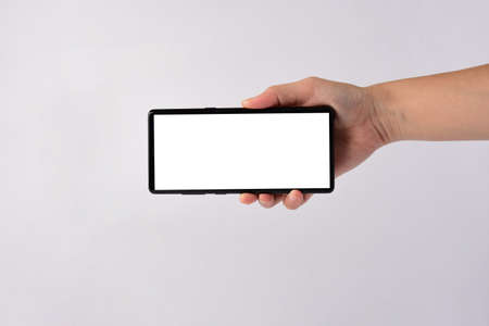 Hand and smartphone with blank white screen and black stylus for writing isolated on white background.の写真素材