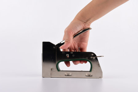 Stapler Pliers and a hand on a white Background